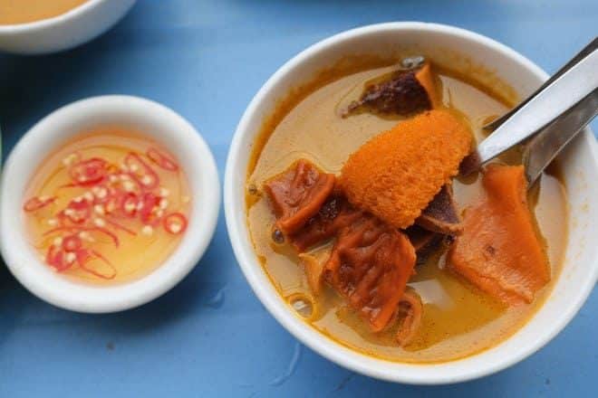 Chén phá lấu bò với nước cốt dừa và chén muối ớt bên cạnh